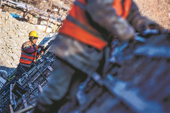 1月3日,房山区,工人正在双泉河修筑堤坝。