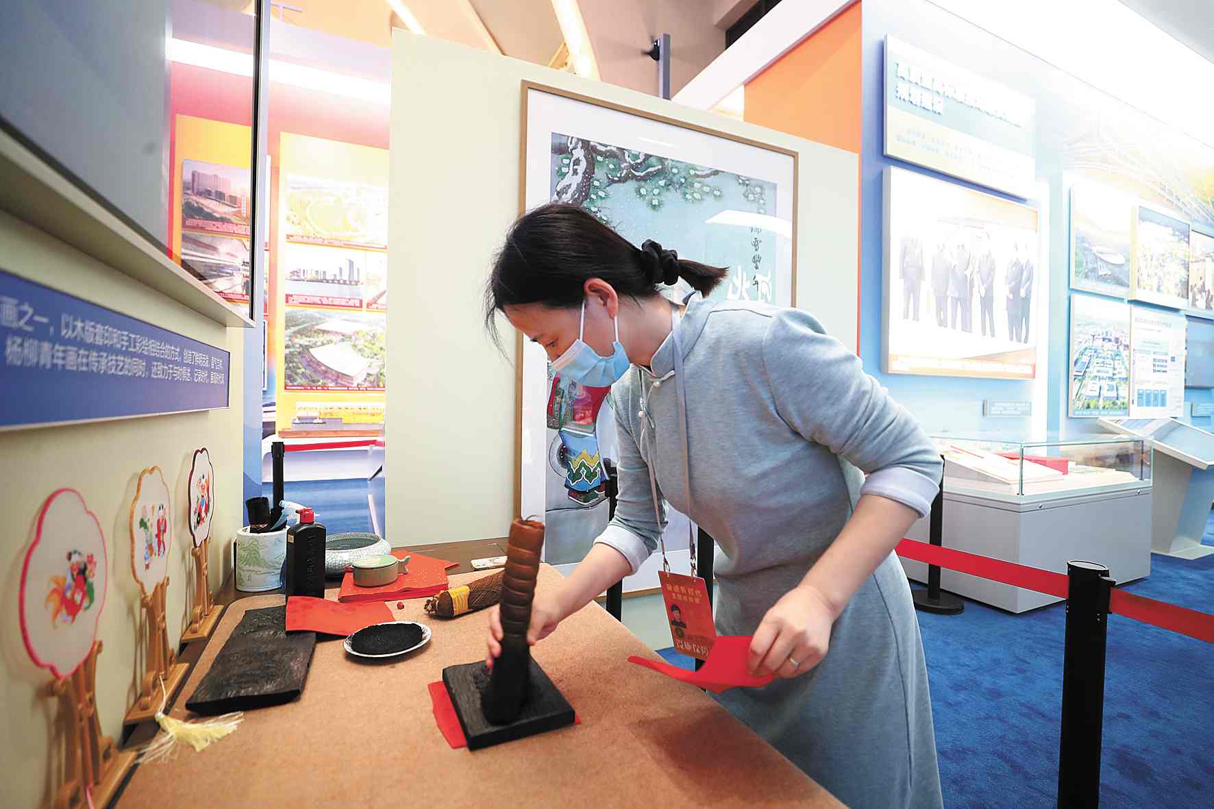在天津展区，杨柳青木版年画代表性传承人张宏现场演示年画印刷。 本报记者 卢 旭 摄
