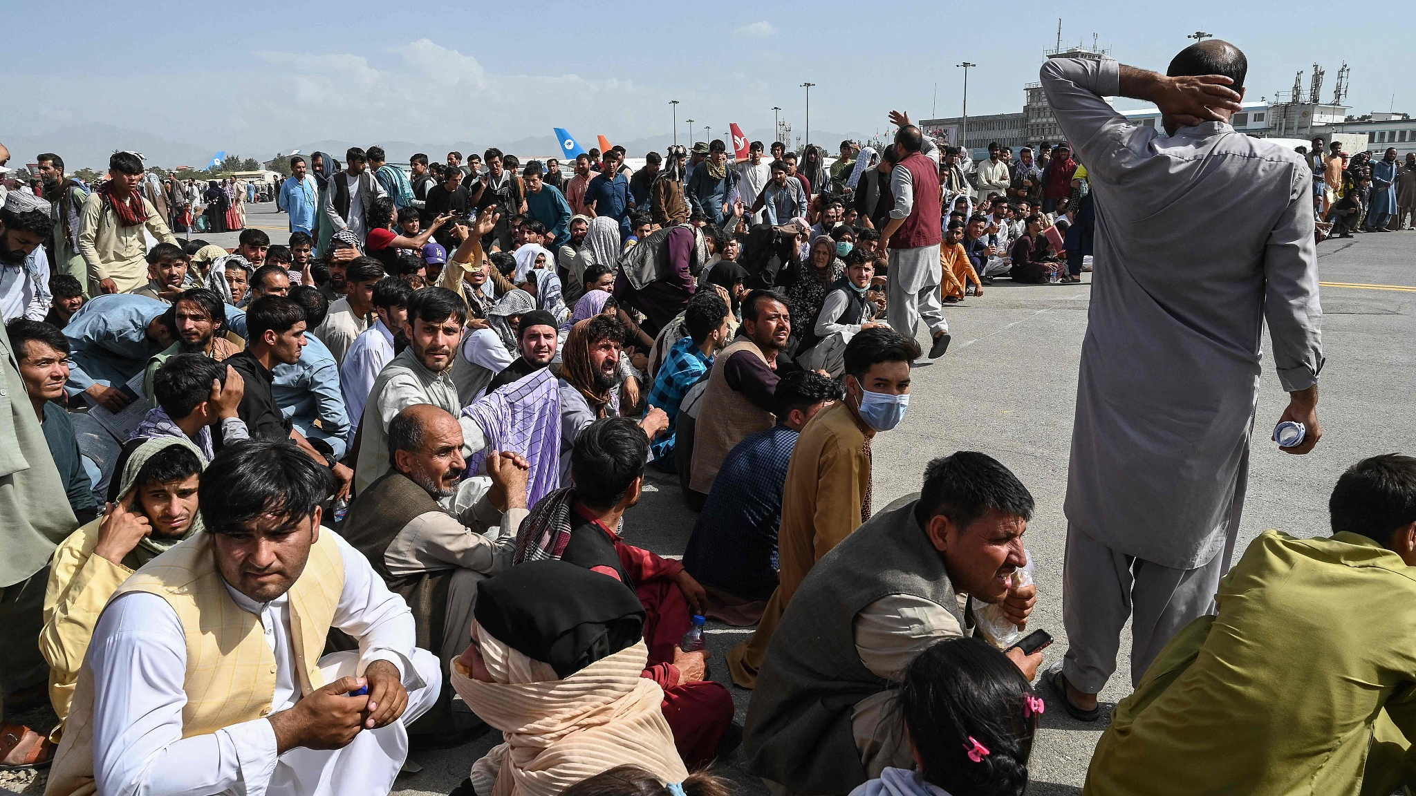 Afghan passengers sit as they wait to leave the Kabul airport, Kabul, Afghanistan, August 16, 2021. 