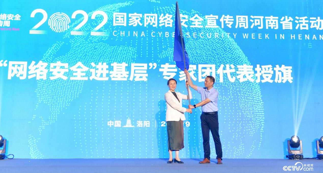 河南省委网信办主任郭岩松（左）向“网络安全进基层”专家团代表授旗