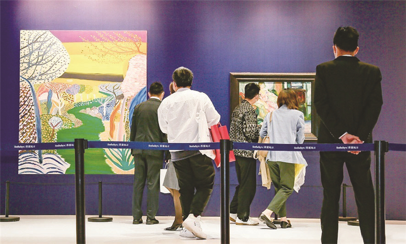 苏富比展台展出王俊杰创作的油画《夕阳之河》与爱德华·蒙克创作的油画《藤椅上的模特》，吸引不少观众驻足观赏。    中国国际进口博览局供图
