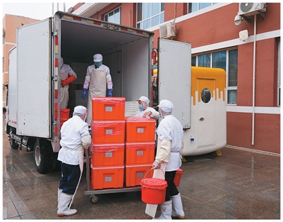 首都师范大学附属小学工作人员将食堂做好的饭菜装车，准备送往该校柳明校区。